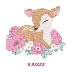 Puede incluir: Diseño bordado de un cervatillo marrón con los ojos cerrados acostado en una cama de flores rosas y blancas. El cervatillo tiene manchas blancas y está rodeado de hojas verdes.