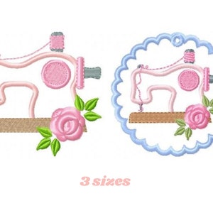 Può includere: Una macchina da cucire rosa con una rosa e foglie verdi, in tre dimensioni, su uno sfondo bianco. La macchina da cucire è in un cerchio blu con un bordo smerlato.