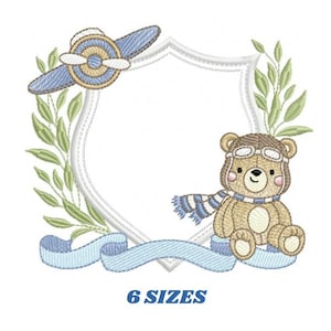 May include: Embroidered design featuring a cute teddy bear wearing aviator goggles and a scarf, sitting next to a blue airplane and a white shield with a blue ribbon. The design is surrounded by green leaves.
