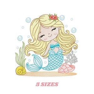 Könnte beinhalten: Stickerei mit einer lächelnden Meerjungfrau mit blonden Haaren, einem blauen Schwanz und einer rosa Blume im Haar. Sie ist von Blasen und Algen umgeben.