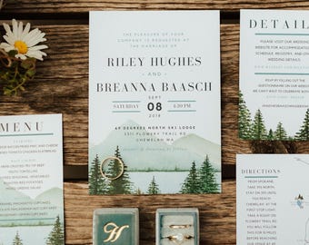 Puede incluir: Conjunto de papelería de boda con temática rústica. El conjunto incluye una invitación, una tarjeta de detalles, un menú y un mapa. El diseño presenta un paisaje montañoso, pinos y un anillo de oro. El fondo de madera tiene el texto "49° NORTH".