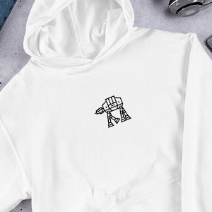 Puede incluir: Sudadera con capucha blanca con un contorno negro de un caminante AT-AT de Star Wars en la parte delantera.