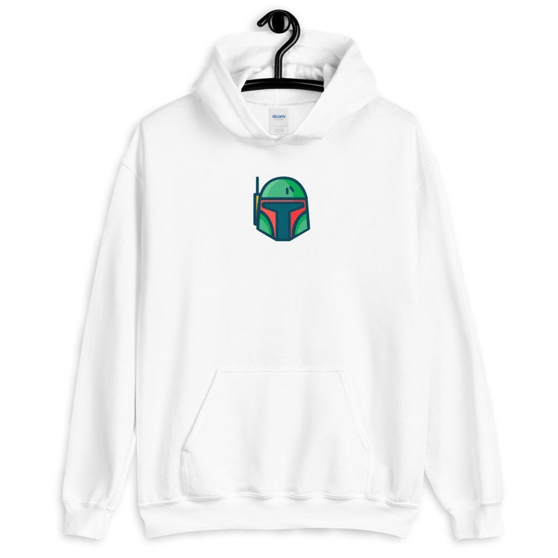 以下が含まれることがあります： 前面に緑、赤、青の漫画のヘルメットのデザインが施された白いフード付きスウェットシャツです。