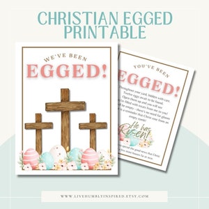 May include: Printable Easter card with a Christian message. The card features three wooden crosses with pastel pink and blue Easter eggs and flowers at the bottom. The text on the card reads "We've Been Eggeded!" and "You've Been Eggeded!" with a message about the resurrection of Christ.