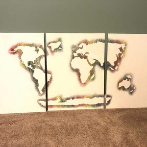 May include: A world map made of colorful dots on three white canvases.