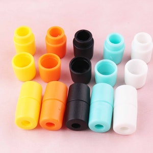 May include: Assortment of colorful plastic cord end stoppers in various colors including yellow, orange, black, blue, and white.