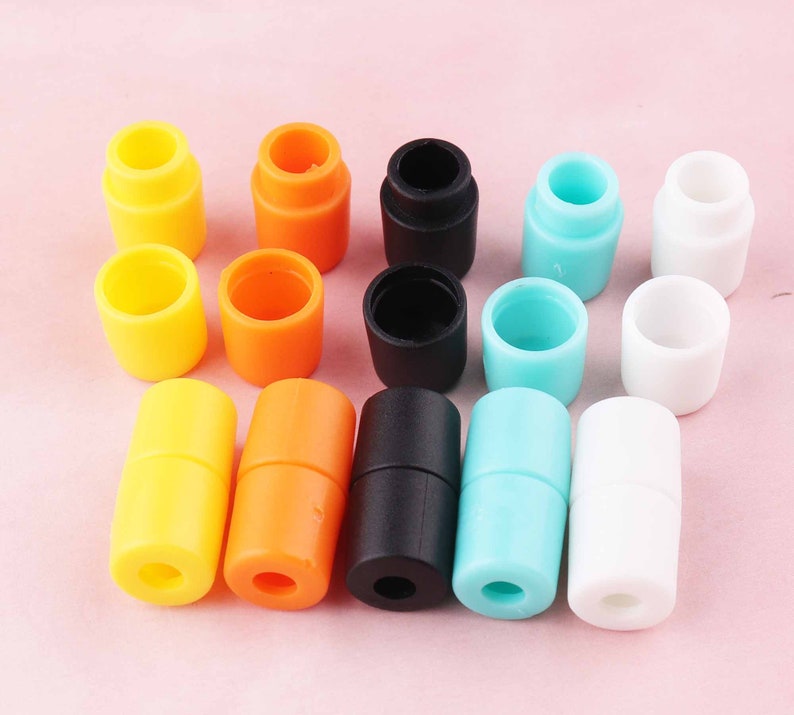 May include: Assortment of colorful plastic cord end stoppers in various colors including yellow, orange, black, blue, and white.