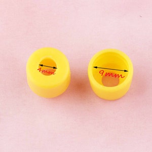 May include: Two yellow plastic caps with different sized holes. The smaller cap has a 4mm hole and the larger cap has a 9mm hole.