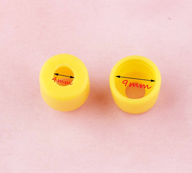 May include: Two yellow plastic caps with different sized holes. The smaller cap has a 4mm hole and the larger cap has a 9mm hole.