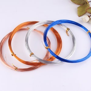 Puede incluir: Cuatro carretes de alambre de diferentes colores: cobre, plata y azul. El alambre es fino y parece ser para la elaboración de joyas.