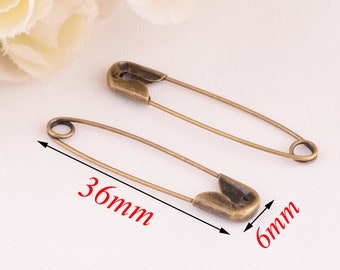 May include: Two antique gold safety pins, one is 36 mm long and the other is 6 mm long.