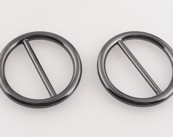 May include: Two black metal rings with a straight bar across the center. The rings are smooth and have a shiny finish.