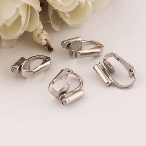 May include: Four silver-toned earring clips for attaching earrings to non-pierced ears. The clips are made of metal and have a spring-loaded mechanism.
