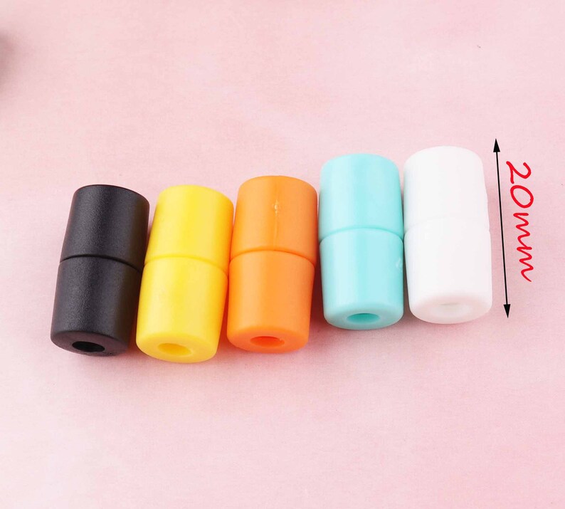 May include: Five plastic cord end stoppers in black, yellow, orange, light blue, and white. Each stopper is 20 mm long.