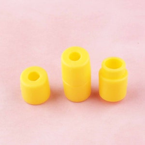 May include: Three yellow plastic cylindrical stoppers of different sizes.