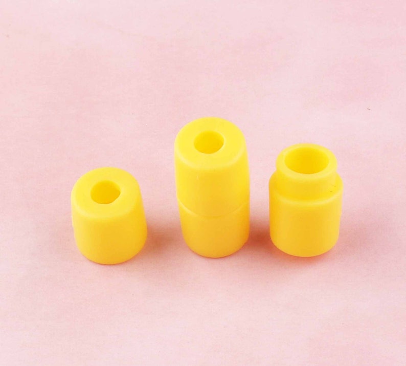 May include: Three yellow plastic cylindrical stoppers of different sizes.