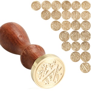 May include: A wooden handle wax seal stamp with a gold metal head featuring a decorative letter "N" design. The set includes 26 alphabet letter heads.