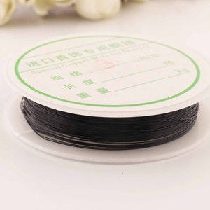 May include: A spool of black elastic cord for jewelry making. The spool is labeled "Special Copper Wire for Jewelry".