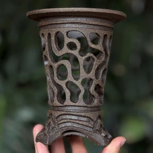 Może przedstawiać: Biały ceramiczny kubek z czarnym uchwytem i napisem "But First, Coffee" czarną, pogrubioną czcionką. Kubek stoi na drewnianej powierzchni. Kubek ma około 10 cm wysokości.