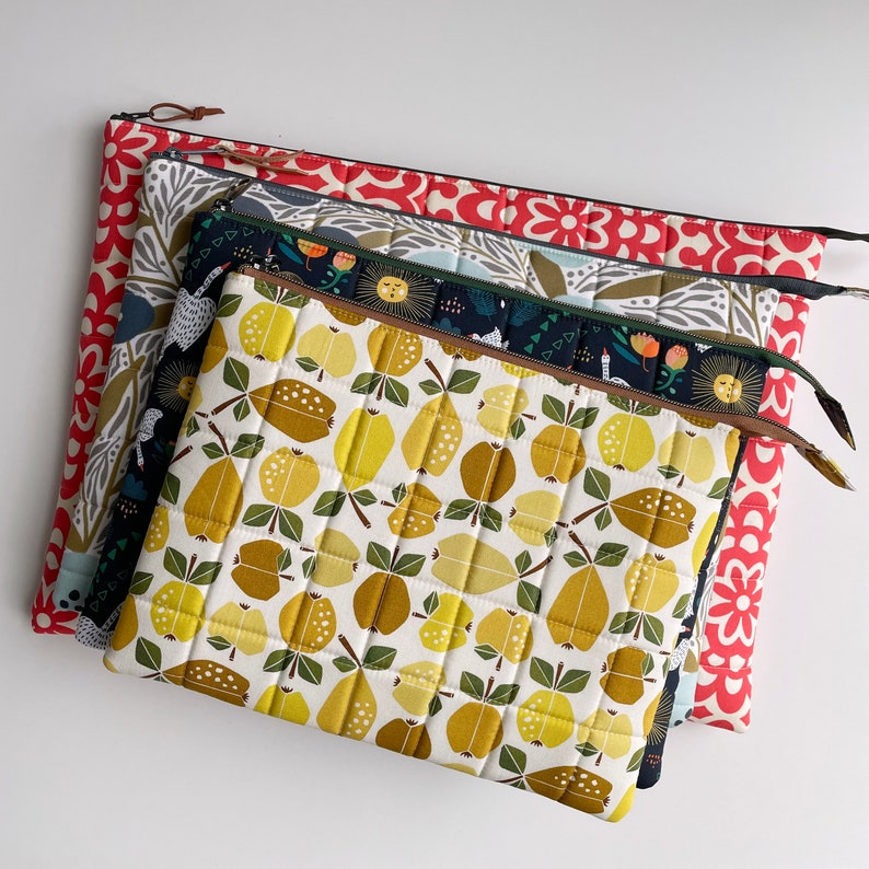 Puede incluir: Cuatro bolsas de tela acolchadas con diferentes patrones. La bolsa superior tiene un patr&oacute;n geom&eacute;trico amarillo y marr&oacute;n con un dise&ntilde;o acolchado. La segunda bolsa tiene un patr&oacute;n floral azul oscuro y verde. La tercera bolsa tiene un patr&oacute;n floral gris y blanco. La bolsa inferior tiene un patr&oacute;n floral rojo y blanco.