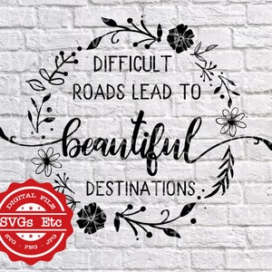 May include: Black and white graphic with a floral wreath and the text "Difficult roads lead to beautiful destinations."
