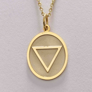 May include: A gold chain necklace with an oval pendant featuring a gold triangle inside. The pendant is a symbol of the element water.