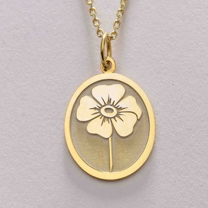 May include: A gold chain necklace with a pendant featuring a delicate flower design. The pendant is oval shaped and has a cutout design.