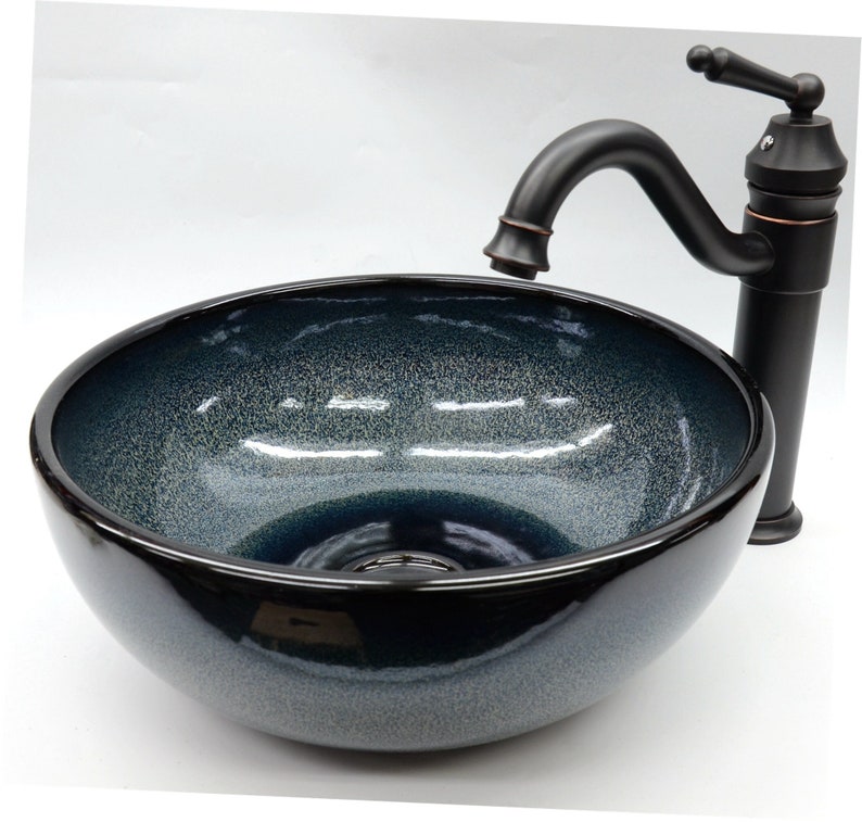 May include: A dark blue ceramic vessel sink with a black faucet. The sink has a speckled finish and a round shape.