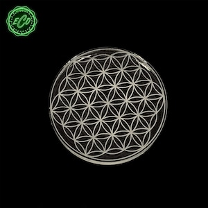 May include: A clear glass coaster with a white flower of life design.