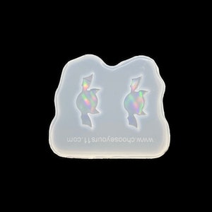 May include: A clear silicone mould with two cavities shaped like bats. The mould is designed for making resin earrings or other small crafts. The text "www.chooseyoursti.com" is printed on the mould.