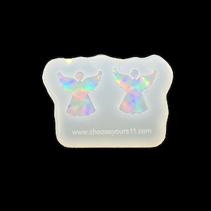 May include: A clear silicone mould with two angel shapes. The angel shapes are iridescent and have a rainbow effect.