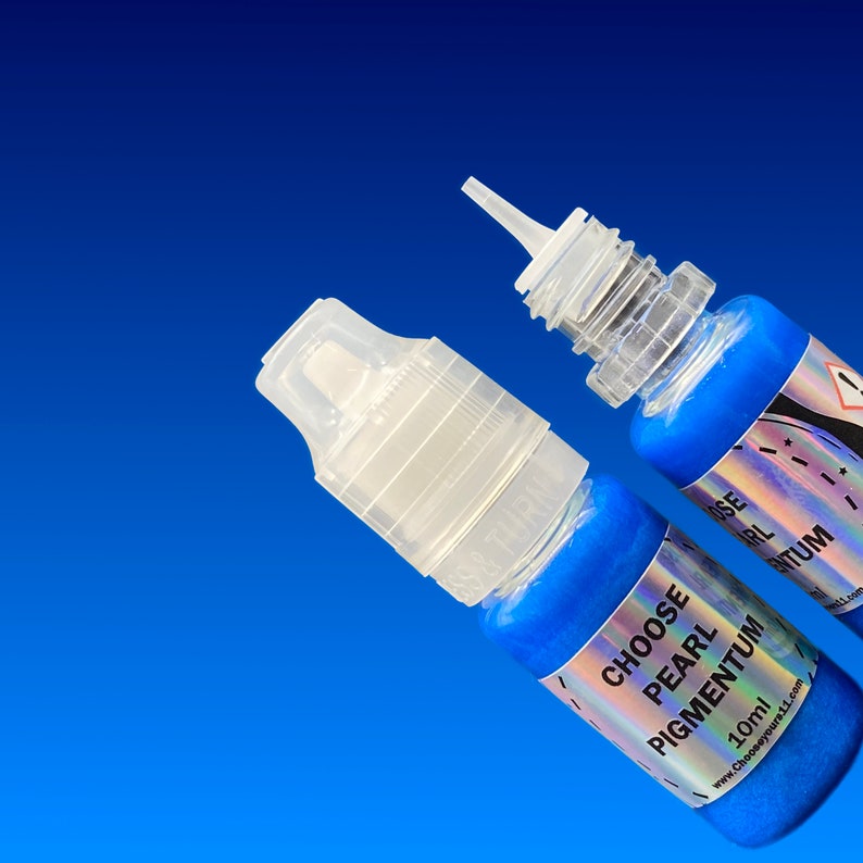 May include: Two small plastic squeeze bottles filled with vibrant blue pearl pigment. Each bottle features a clear cap and a label with the text CHOOSE PEARL PIGMENTUM 10ml. The bottles are positioned against a solid blue background.