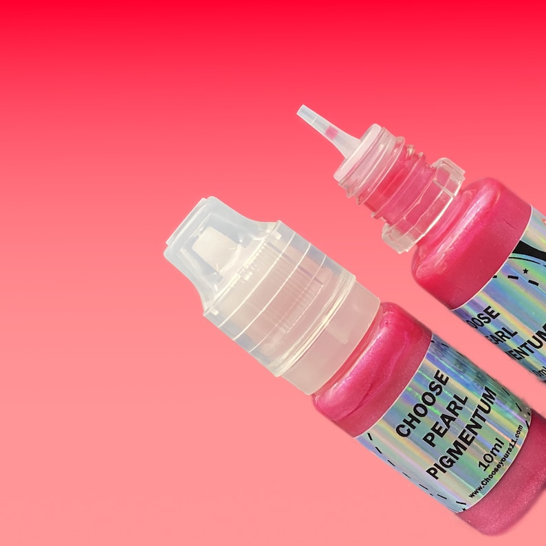 May include: Two small plastic squeeze bottles filled with vibrant pink pearl pigment. Each bottle features a clear cap and a holographic label with the text CHOOSE PEARL PIGMENTUM 10ml and the website address Chooseyours11.com printed clearly.