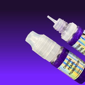 May include: Two small clear plastic squeeze bottles filled with deep purple glittery liquid. Each bottle features a holographic label with the text CHOOSE PEARL PIGMENTUM 10ml. One bottle has a clear cap, while the other is open with a nozzle.