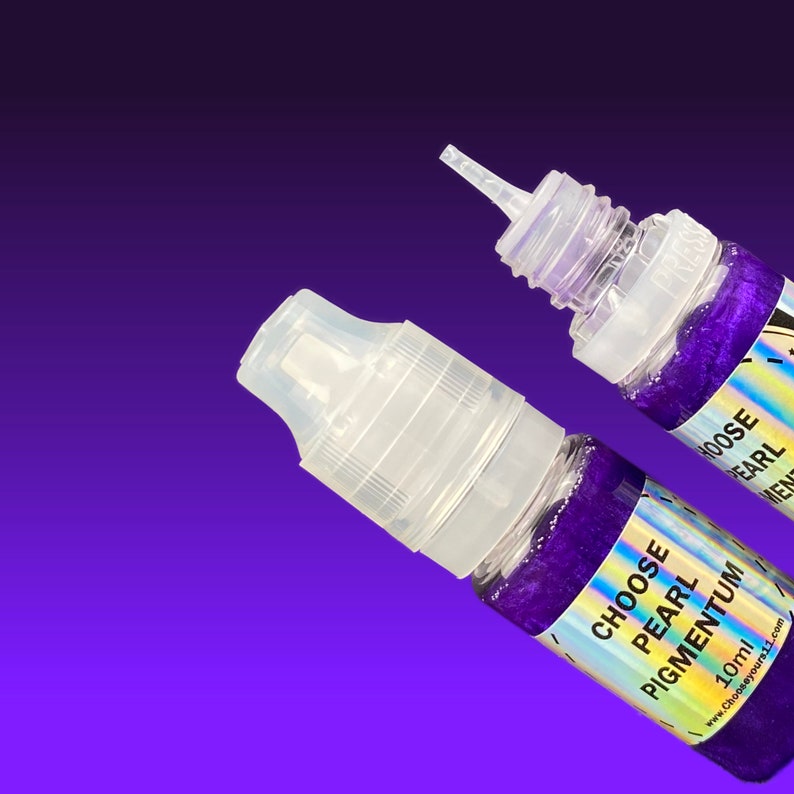 May include: Two small clear plastic squeeze bottles filled with deep purple glittery liquid. Each bottle features a holographic label with the text CHOOSE PEARL PIGMENTUM 10ml. One bottle has a clear cap, while the other is open with a nozzle.