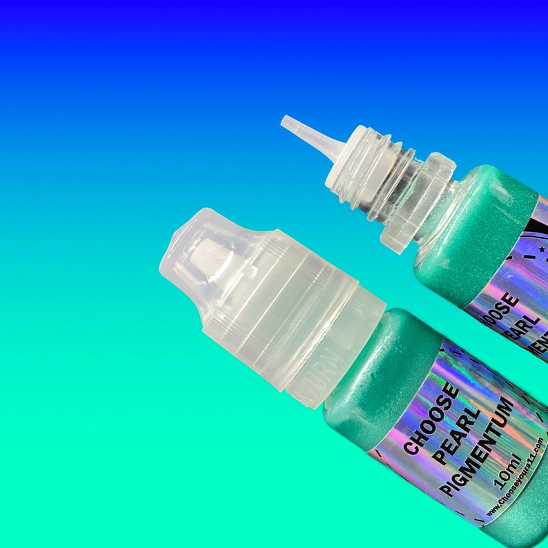 May include: Two small squeeze bottles containing shimmering mint green pigment. Each bottle features a clear plastic cap and a holographic label with the text CHOOSE PEARL PIGMENTUM 10ml and the website address www.chooseyours11.com printed on it.