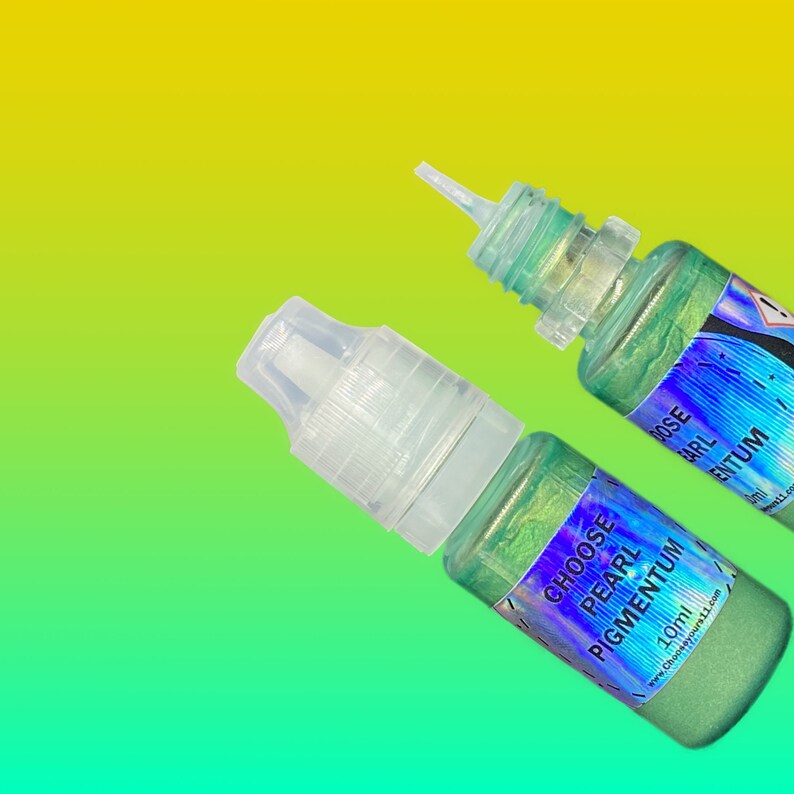 May include: Two small plastic squeeze bottles containing shimmering green liquid pigment. Each bottle features a clear cap and a holographic label with the text CHOOSE PEARL PIGMENTUM 10ml and the website address chooseyours11.com printed clearly.