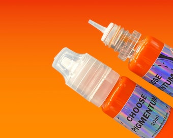 Może przedstawiać: Dwie butelki pomarańczowego pigmentu do atramentu z holograficzną etykietą z napisem "Choose Pigmentum" i "40ml". Etykieta zawiera również adres strony internetowej "www.ChooseYourArt.com".
