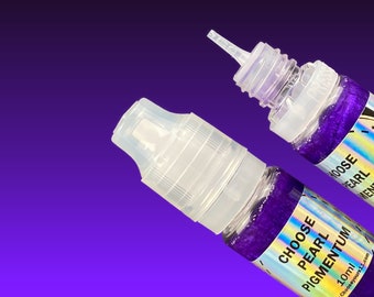 May include: Two clear bottles with dropper tops filled with purple glitter. The bottles have labels that say "Choose Pearl Pigmentum" and "10ml".