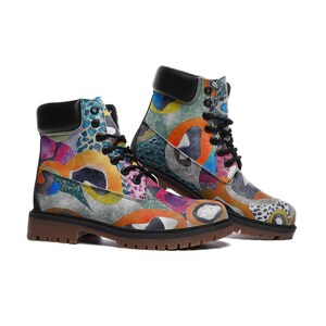 May include: A pair of colorful patterned lace-up boots with a black leather upper and a brown rubber sole.