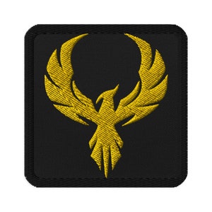 May include: A black embroidered patch with a gold phoenix design. The phoenix is in flight with its wings spread wide.