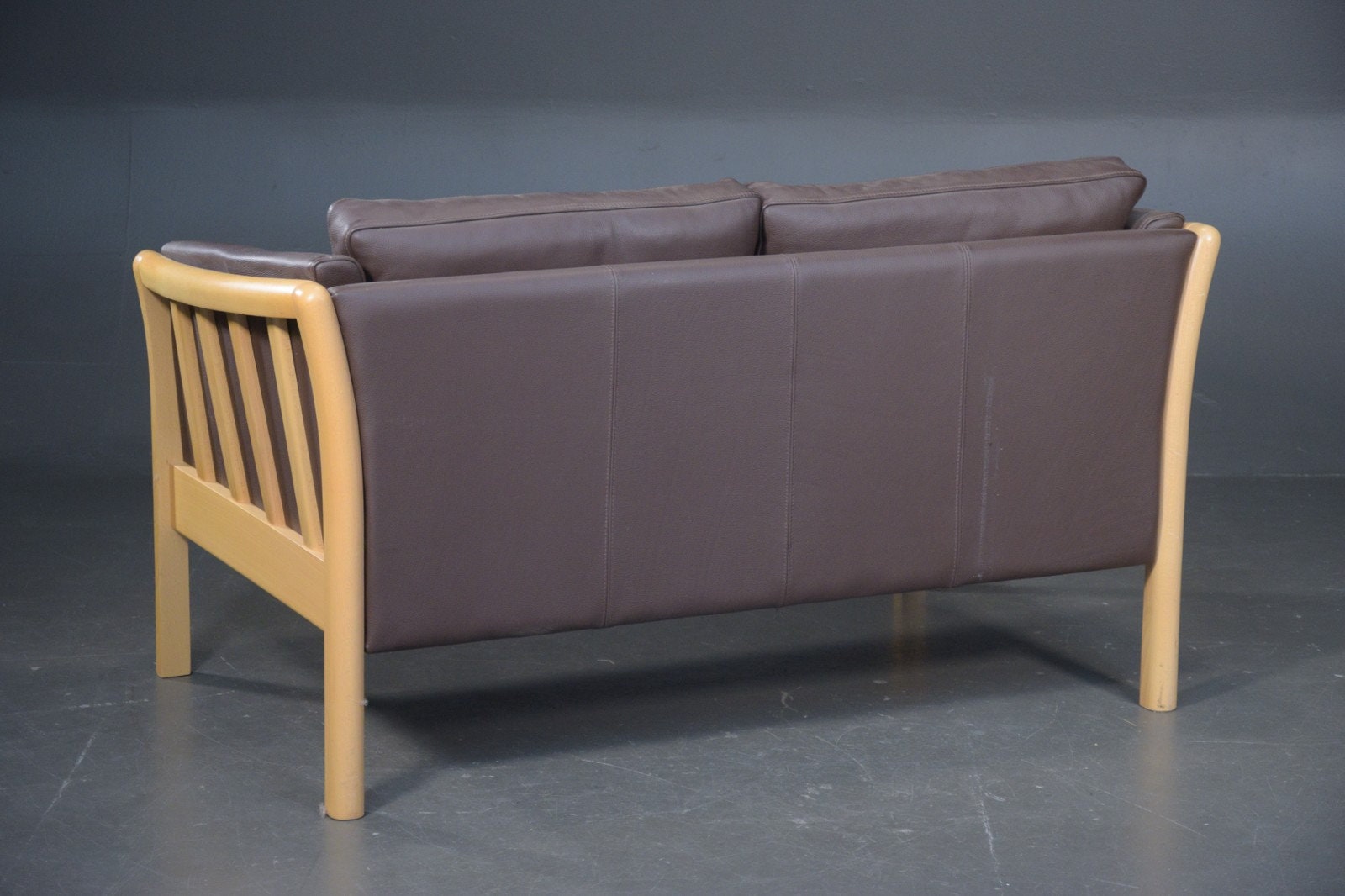 Danish two seater brown leather sofa with wooden frame