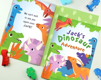 Puede incluir: Un libro infantil personalizado titulado "La aventura de los dinosaurios de Jack". La portada presenta ilustraciones coloridas de dinosaurios en un entorno de jungla. El libro es perfecto para niños pequeños que aman los dinosaurios.