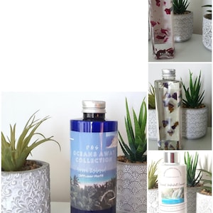 Op de afbeelding: Een collectie navulflesjes voor diffusers in diverse maten en kleuren, waaronder een hoge blauwe fles met het label P&S Oceans Away Collection Greek Island, naast doorzichtige flessen met bloemen en een witte fles met een watervalafbeelding.