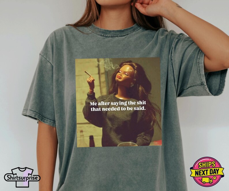 K&ouml;nnte beinhalten: Graues T-Shirt mit einem aufgedruckten Bild einer rauchenden Frau und dem Text "Me after saying the shit that needed to be said." Das Shirt hat auch das Logo "Shirtsurprise" und eine "Ships Next Day" Grafik.