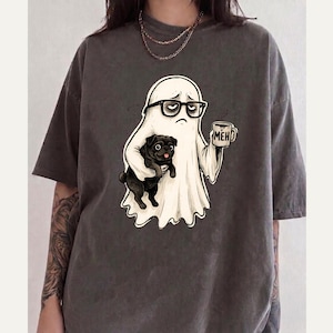 May include: A charcoal grey short-sleeve t-shirt featuring a graphic of a white ghost wearing black glasses, holding a black pug in one arm and a coffee mug labelled MEH in the other hand. The design is centred on the chest of the garment.