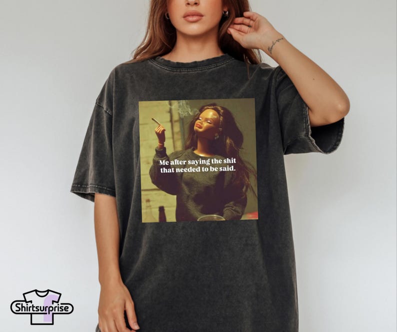 K&ouml;nnte beinhalten: Dunkelgraues T-Shirt mit einem Aufdruck einer Frau mit Zigarette und dem Text "Me after saying the shit that needed to be said." Das Shirt hat eine lockere Passform und kurze &Auml;rmel.