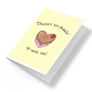 May include: A yellow card with the text "Thanks for Puddin' up with me!" and a cartoon heart-shaped chocolate dessert with a strawberry on top.