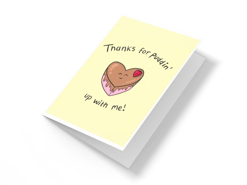 May include: A yellow card with the text "Thanks for Puddin' up with me!" and a cartoon heart-shaped chocolate dessert with a strawberry on top.