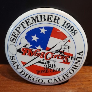 May include: A white button with the text "SEPTEMBER 1998" and "SAN DIEGO, CALIFORNIA" in a circular design. The button features a red, white, and blue design with a plane and the words "Flying Circus" and "380 BOMB GROUP".